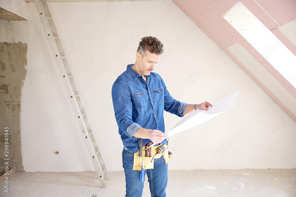 Construction man holding blueprint in his hand and working