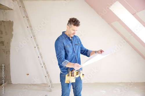 Construction man holding blueprint in his hand and working