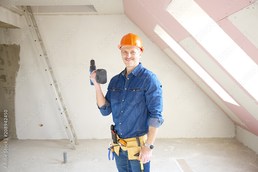Smiling mature construction man portrait with handyman belt and safety helmet and drill Smiling mature construction man portrait with handyman belt and safety helmet and drill