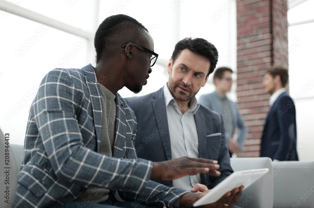 two businessmen use a digital tablet two businessmen use a digital tablet
