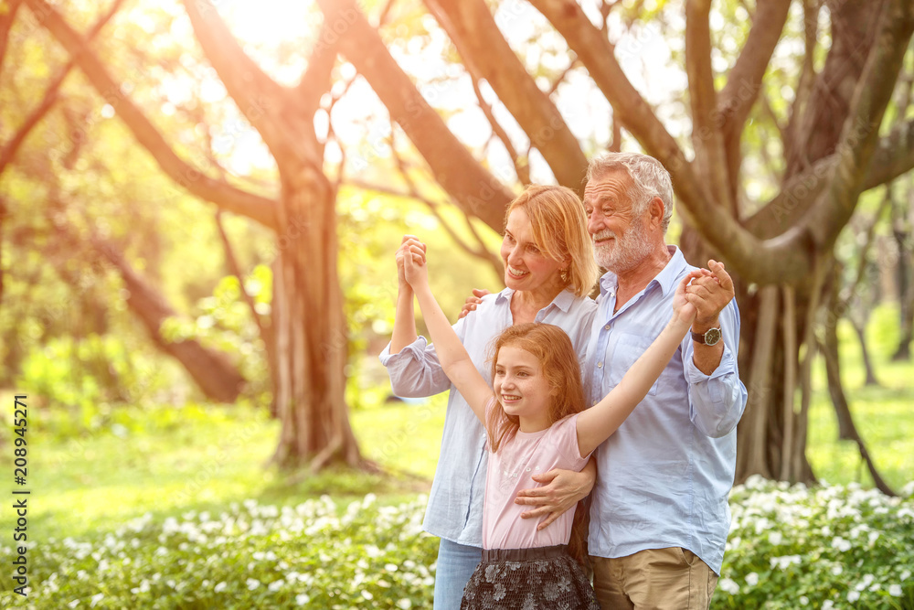 Fototapeta premium Happy family and daughter playing together in the garden. Soft focus concept.