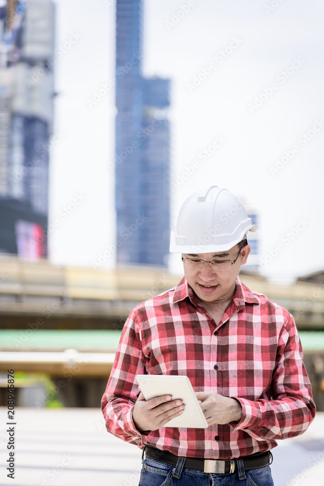 Fototapeta premium Asian business and engineer man with red scott shirt has planning and working for design buiding and city.