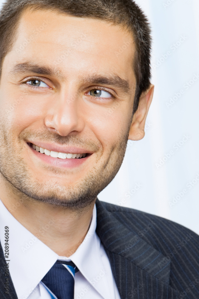 Happy smiling young businessman at office Happy smiling young businessman at office