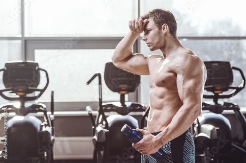 handsome strong bodybuilder athletic men pumping up muscles with dumbbells © antondotsenko