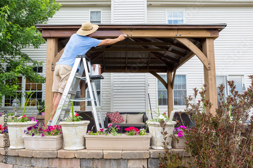 Photography Homeowner staining a new gazebo in his backyard
