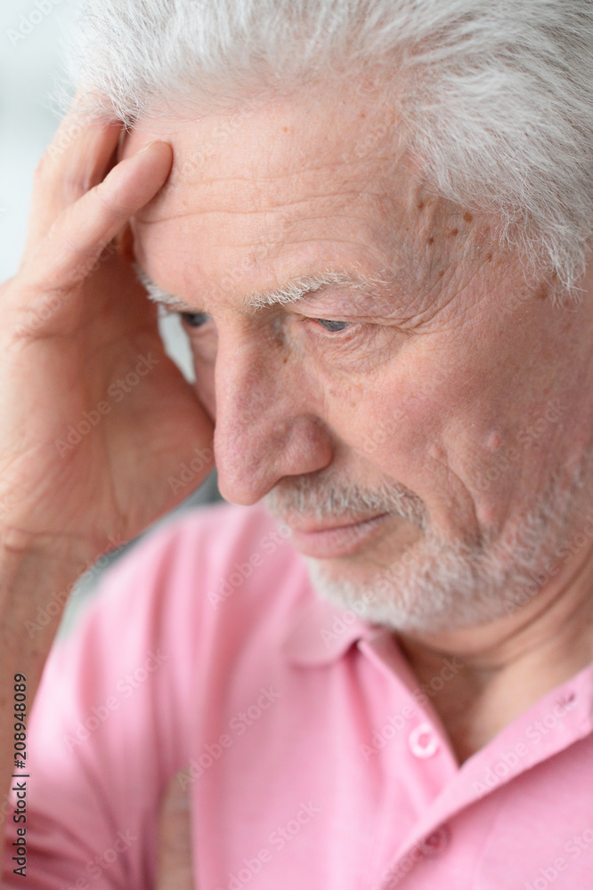 Senior man with headache at home Senior man with headache at home