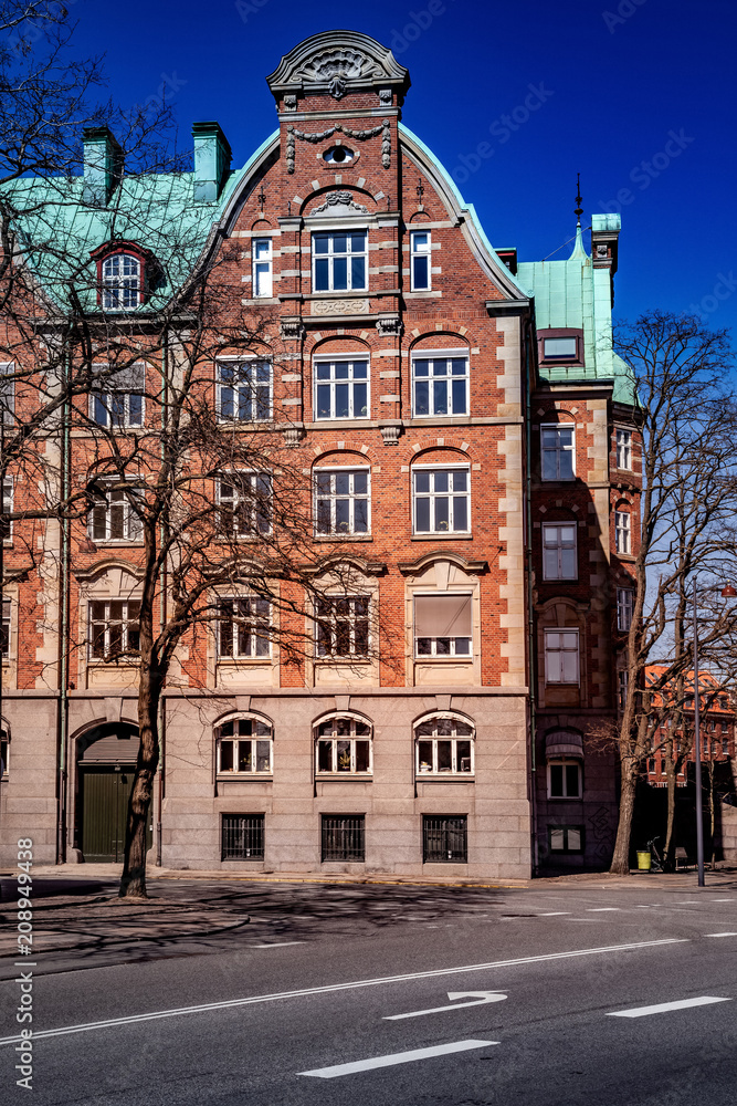 beautiful old building with large windows and decorations on empty street in copenhagen, denmark
