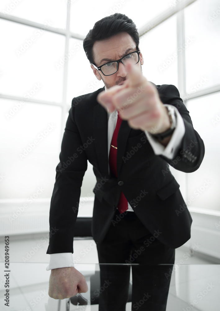 strict businessman pointing finger at you while standing in his office strict businessman pointing finger at you while standing in his office
