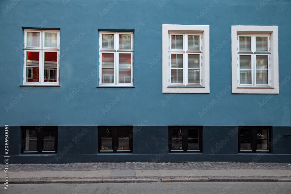 detail of blue and grey building with white windows on street in copenhagen, denmark detail of blue and grey building with white windows on street in copenhagen, denmark
