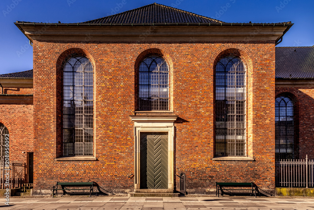 beautiful brown building with large windows in empty street in copenhagen, denmark