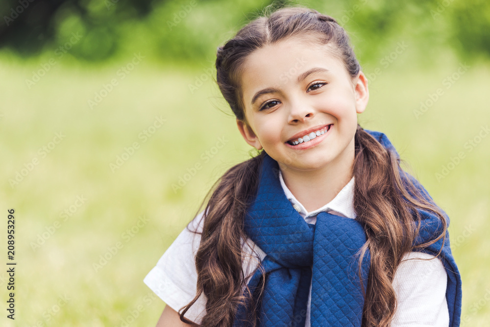 close-up portrait of beautiful schoolgirl in stylish clothes in park