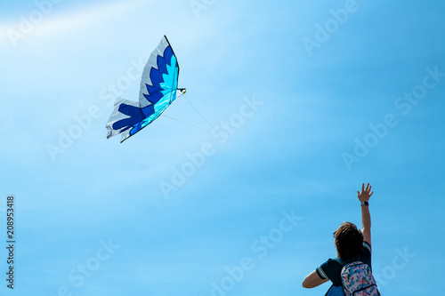 Girl is running the flying kite in the sky