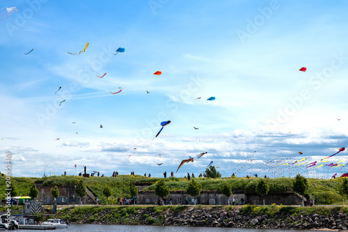Colorful kite festival on blue cloudy sky