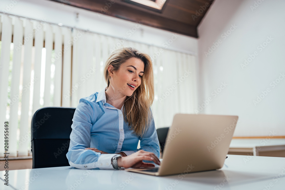 Young female office worker using laptop. Young female office worker using laptop.
