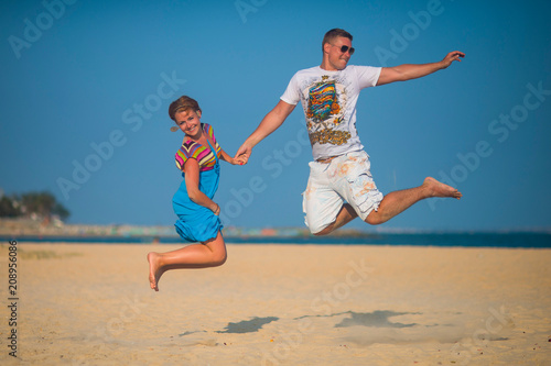 Loving couple having fun jumping on the beach