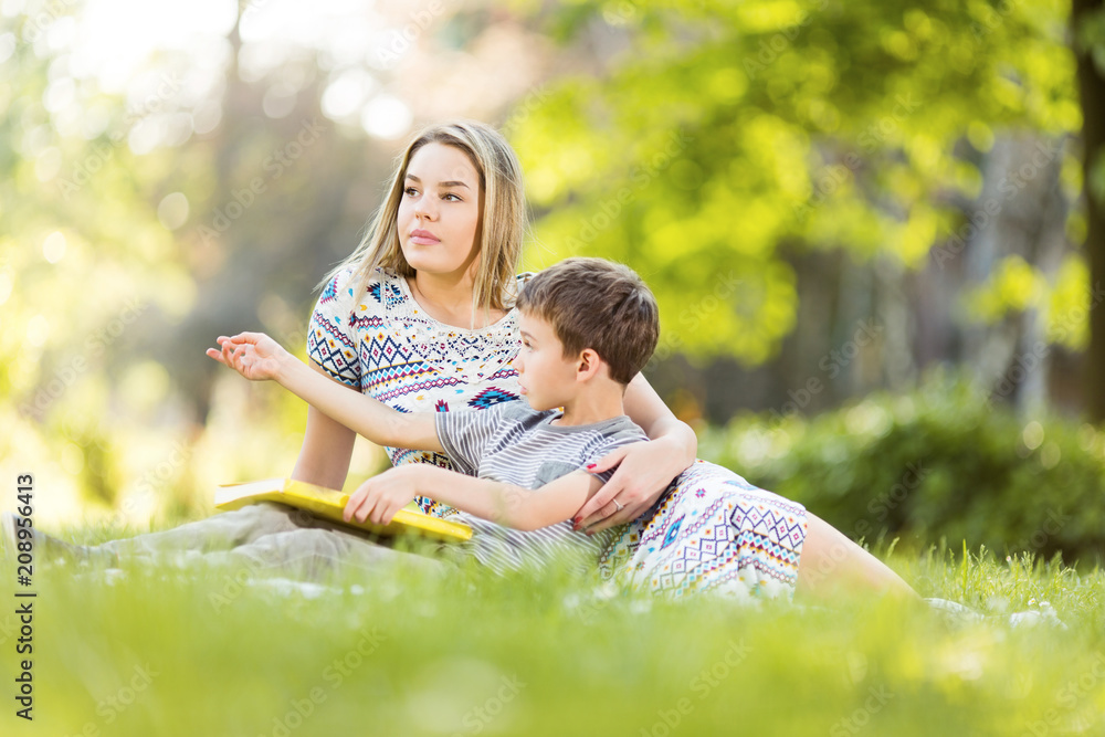 Fototapeta premium Mother and son in park with book