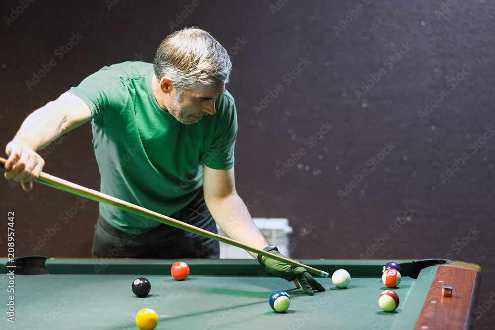 Fototapeta premium a pool player takes aim at the ball
