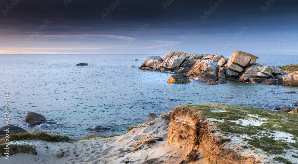 Sunset coastline with sand and stones in Brittany, France
