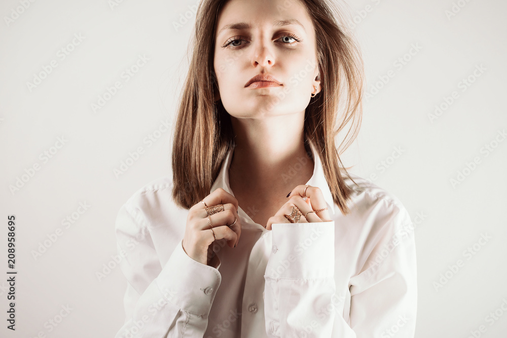 Portrait of young adult woman with eyes closed holding collar of white shirt with her hands, selective focus Portrait of young adult woman with eyes closed holding collar of white shirt with her hands, selective focus