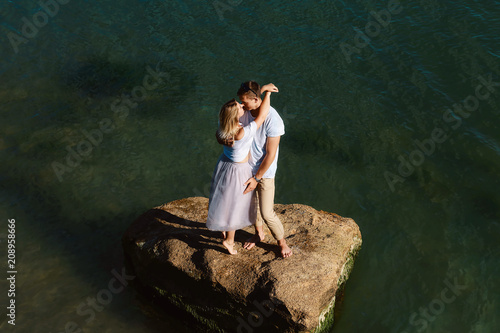 young couple in love cuddling on a rock islands in the middle of the sea water, Black Sea, Odessa, Ukraine, place for text set selective focus