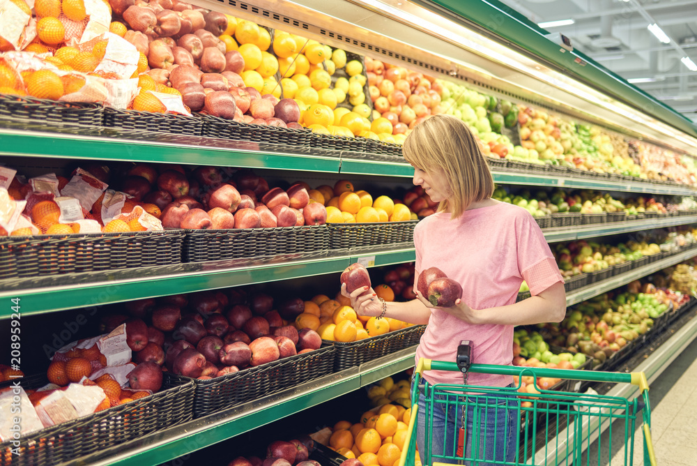 Slender young woman shopping healthy food in supermarket.