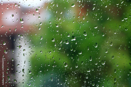Rain drops on window glass with green in background