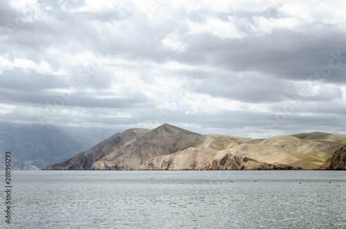 tranquil sea landscape and sunny mountaint in background