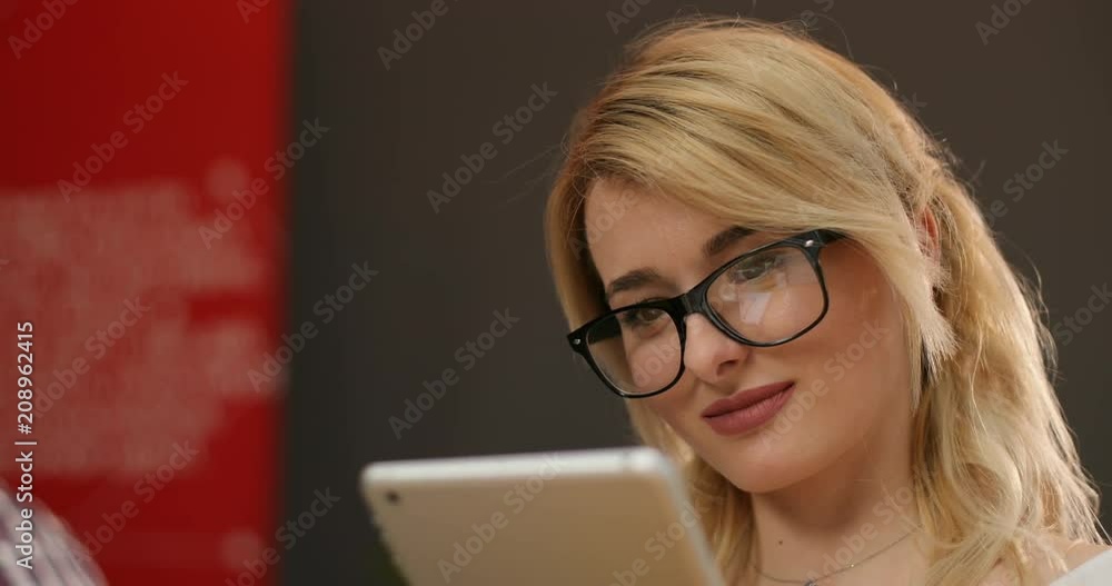 Portrait of gorgeous young businesslady in glasses at her workplace using tablet computer Portrait of gorgeous young businesslady in glasses at her workplace using tablet computer