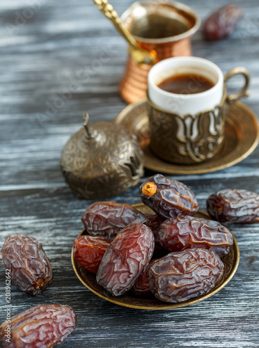 Dates on the plate, copper cezve and black coffee.