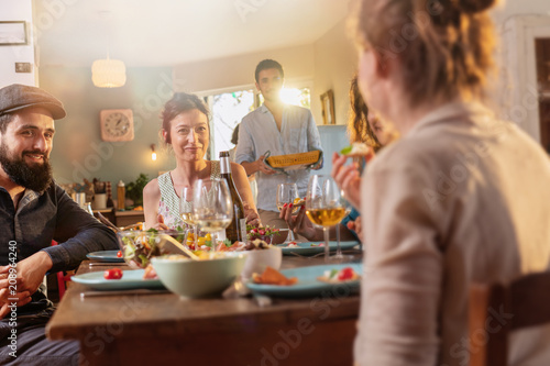 Mixed group of friends having fun while sharing a meal 