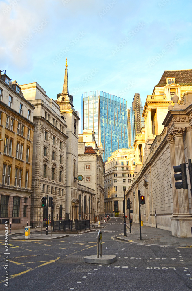 Fototapeta premium View of Lothbury Street in London Banking District, overlooking a skyscraper and St. Margaret's Church on the left.