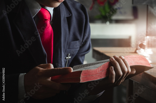 Young man reading and studying the bible.