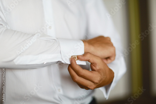 close up of a hand man how wears white shirt and cufflink  with stones  luxurious wedding selective focus