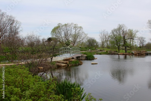 The walkway bridge over the pond on a overcast day.