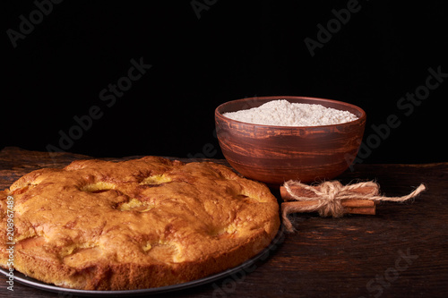 apricot pie and a bowl with flour and other ingredients and tools table photo