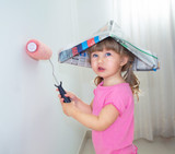 The child paints the wall with a roller