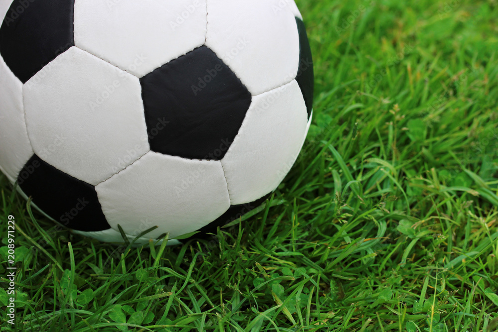 Football black and white ball close-up on the green grass. Football black and white ball close-up on the green grass.