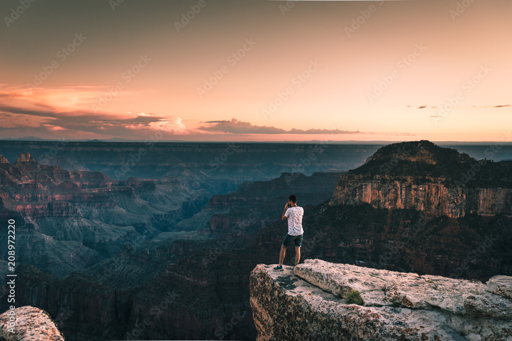 young man taking picture of Magnificent view of Grand Canyon, Arizona, USA.