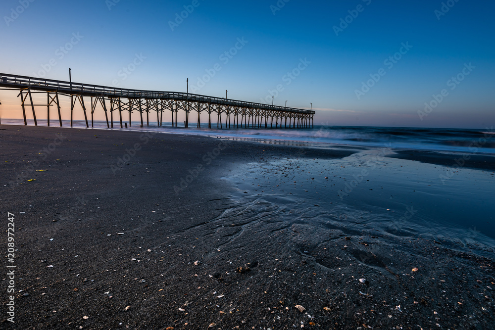 pier along the NC coast in Holden Beach with early morning clear blue skys