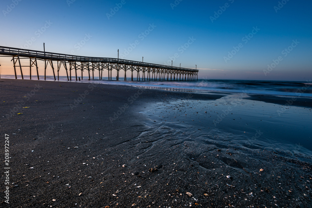 Fototapeta premium pier along the NC coast in Holden Beach with early morning clear blue skys