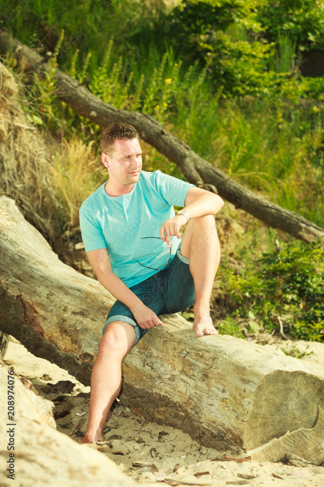 Naklejka premium Handsome man relaxing on beach during summer.