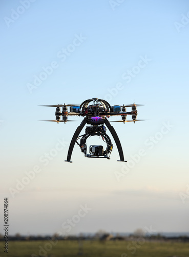 Heavy drone with professional cinema camera flying photo