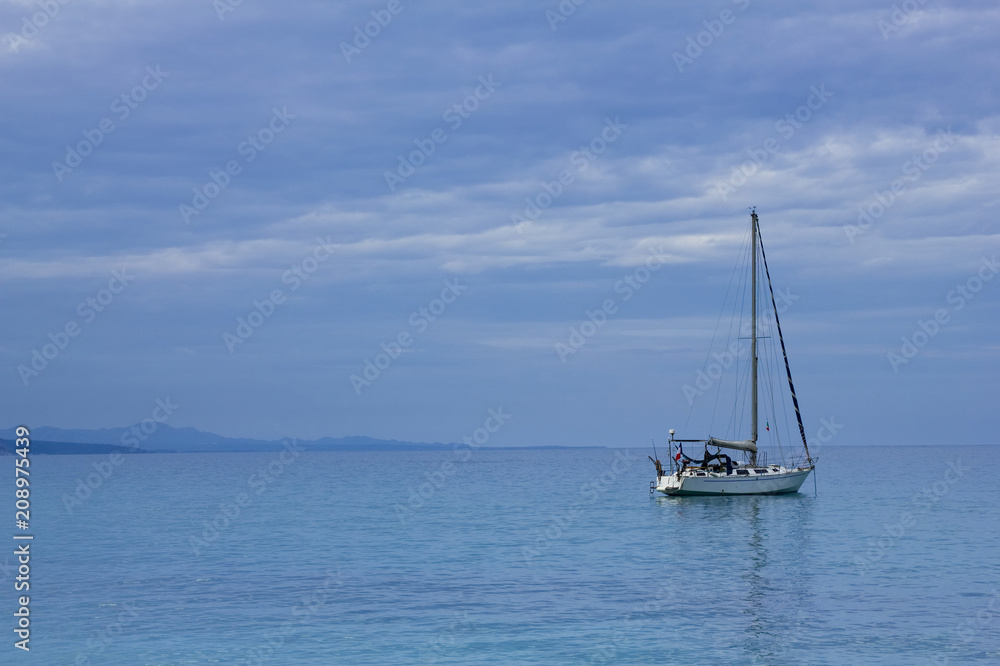 Lonely sailboat on the mediterranean sea at Sardegna coastline