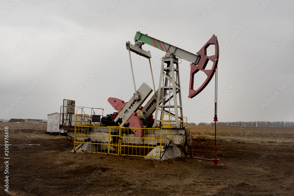 The beam pumping unit is homework, sunset in oil field. Oil pump oil rig energy industrial machine for petroleum. The pumping unit as the pump installed on a well. Equipment of oil fields. The beam pumping unit is homework, sunset in oil field. Oil pump oil rig energy industrial machine for petroleum. The pumping unit as the pump installed on a well. Equipment of oil fields.