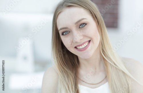 close-up portrait of a young woman on a blurred office background.