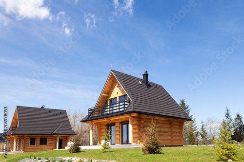 Traditional wooden mountain homes on green field