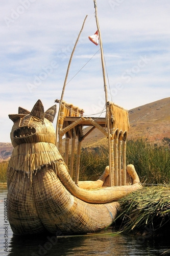 Reed boat with dragon at bow , used to transport tourists, near Uros indian village floating island in lake Titicacca, Peru photo