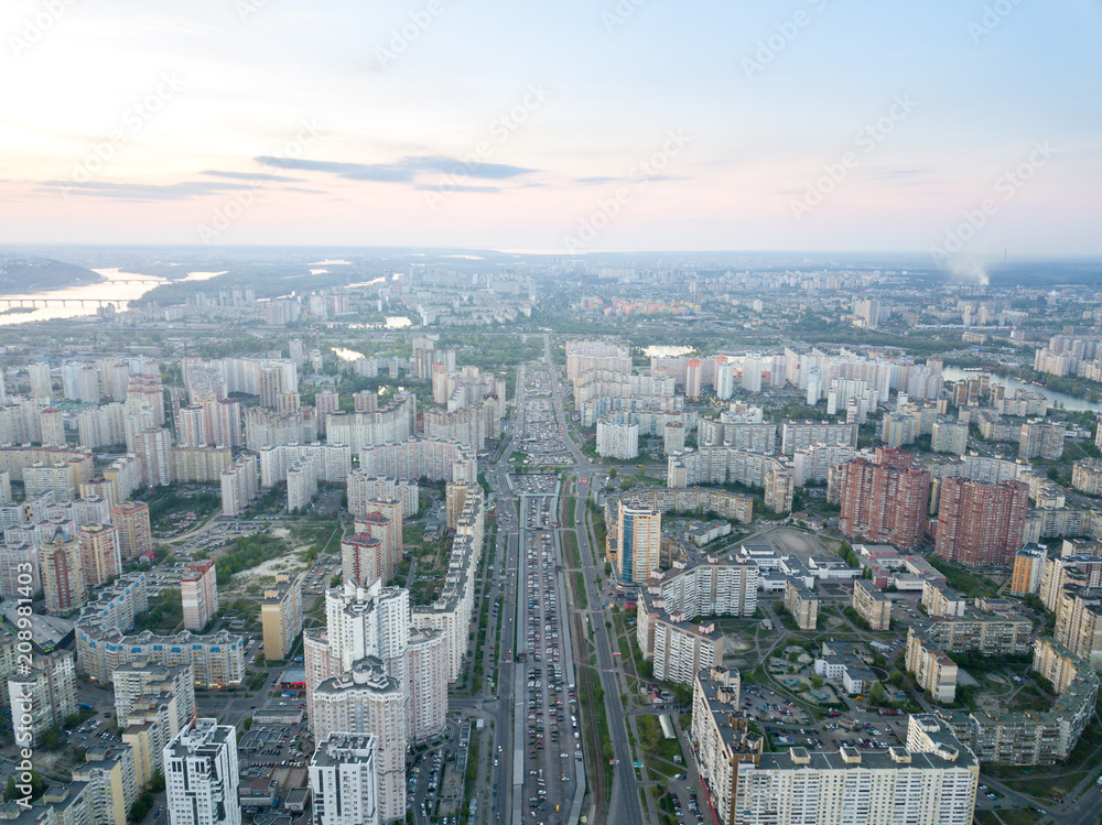 A bird's eye view, aerial panoramic view from drone to the Darnyts'kyi district of Kiev, Ukraine and view to the right bank of Dnieper at sunset in the summer.