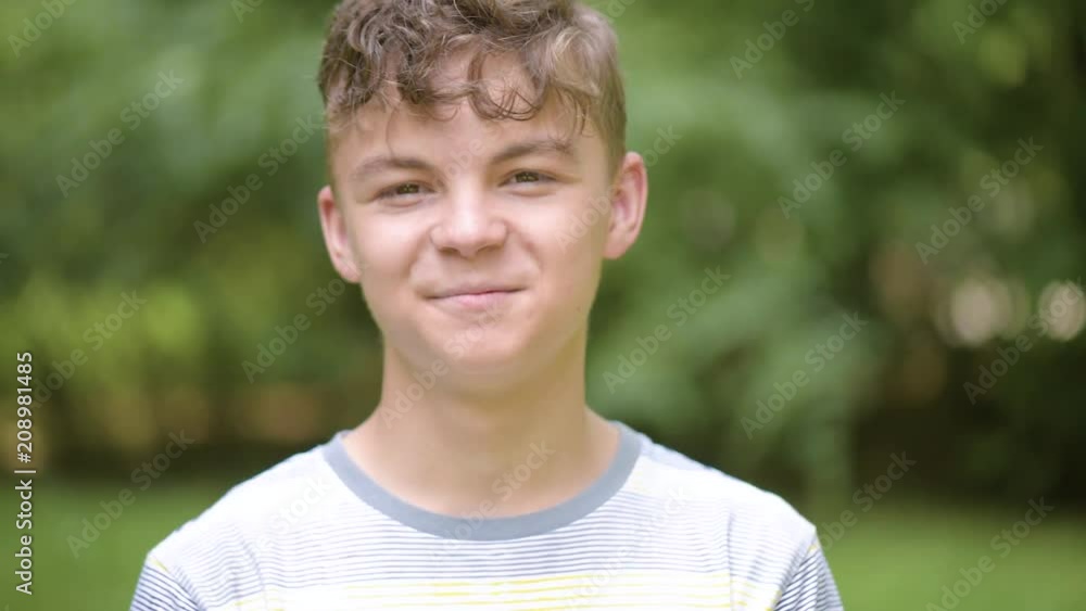 Close up emotional portrait of caucasian smiling teen boy. Handsome guy. Funny cute teenager in summer park at day. Child looking at camera. Close up emotional portrait of caucasian smiling teen boy. Handsome guy. Funny cute teenager in summer park at day. Child looking at camera.