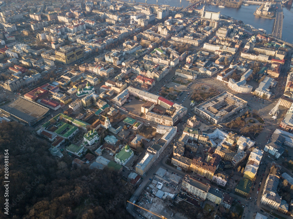 Obraz premium The panoramic bird's eye view from drone to the central historical part of the city Kiev - the Podol district, the Dnieper River in Kiev, Ukraine at summer sunset.